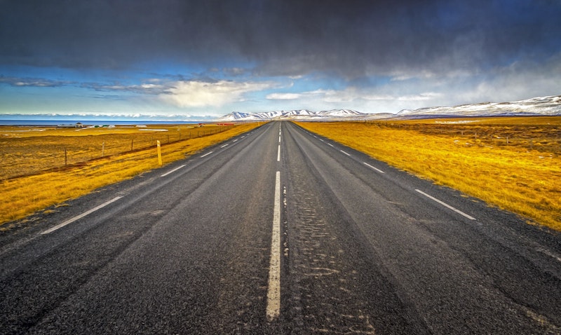 A straight road ahead with mountains off to thedistance